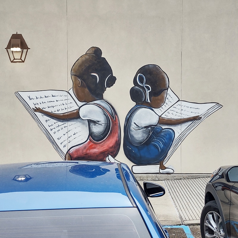 painting of two children sitting back to back reading